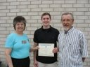 Austin Sietz, scholarship winner receives his certificate from Harriet West, Zone D President as his father Larry Sietz (PWP Ann Arbor 38) looks on.